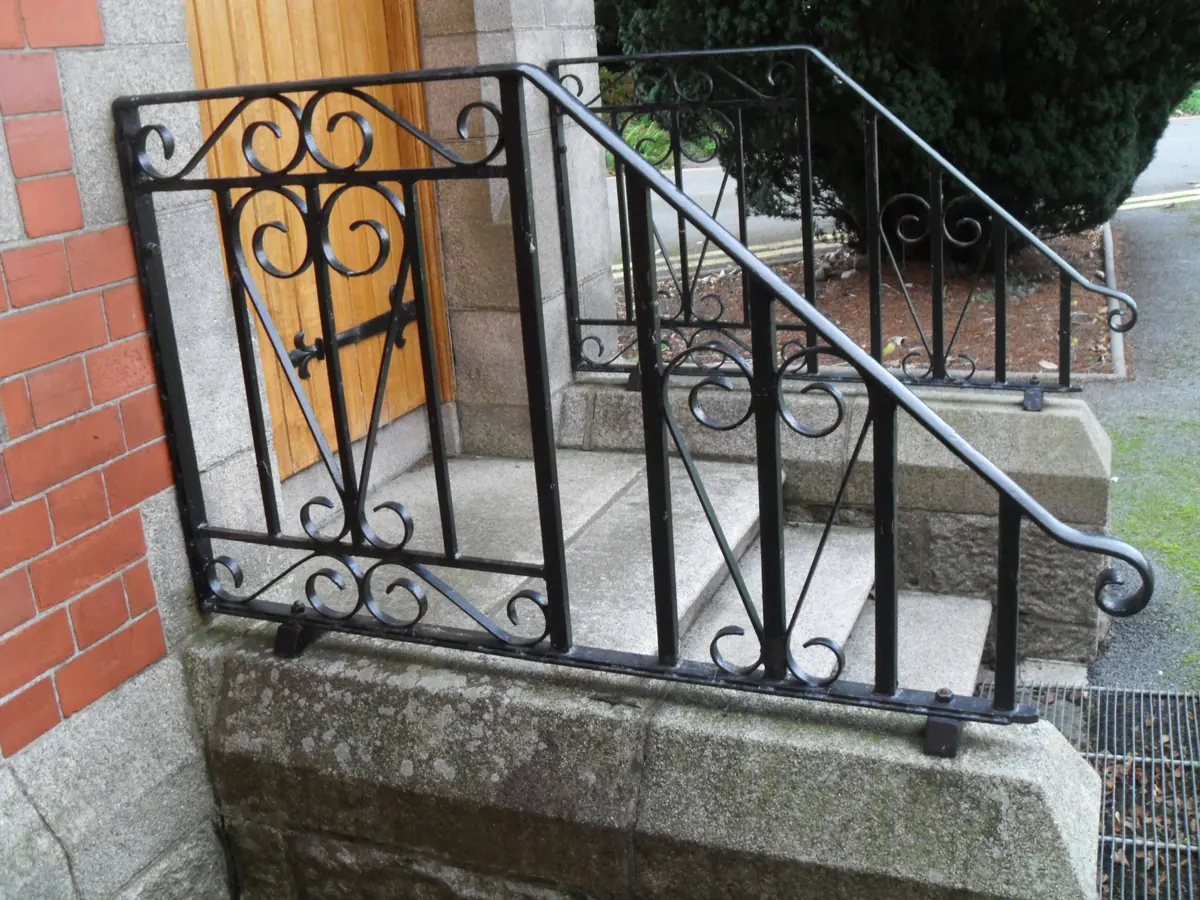 Black wrought steel church handrail on stone steps