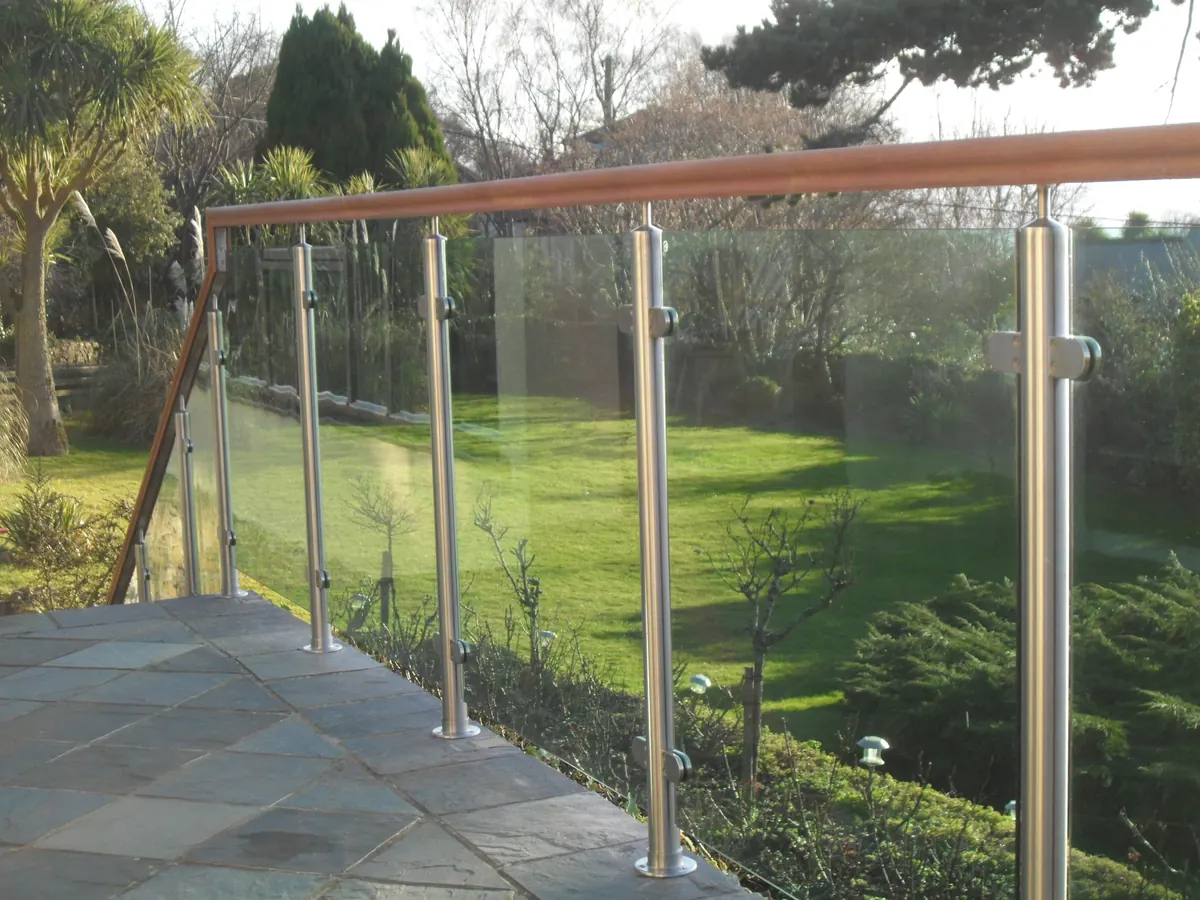 Stainless and timber handrail with glass infill over a garden