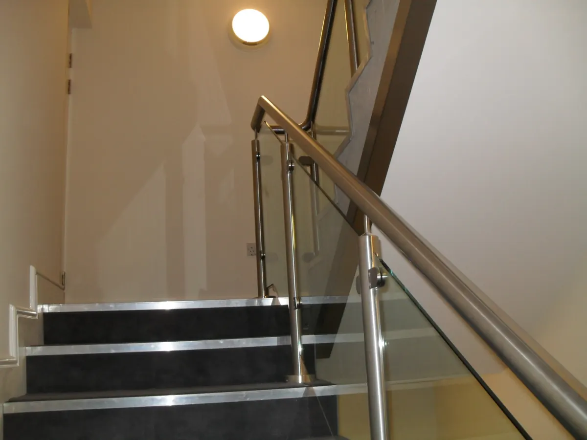 Stair well with glass panel and stainless rail